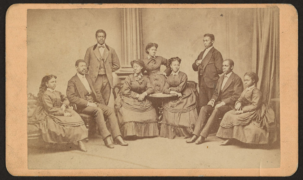 sepia-toned image from the 1870s of Black men and women in period garb posing elegantly