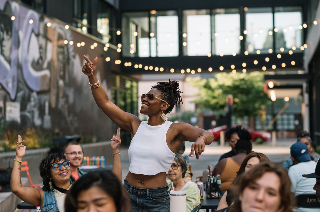 Woman joyfully dances outdoors at night.