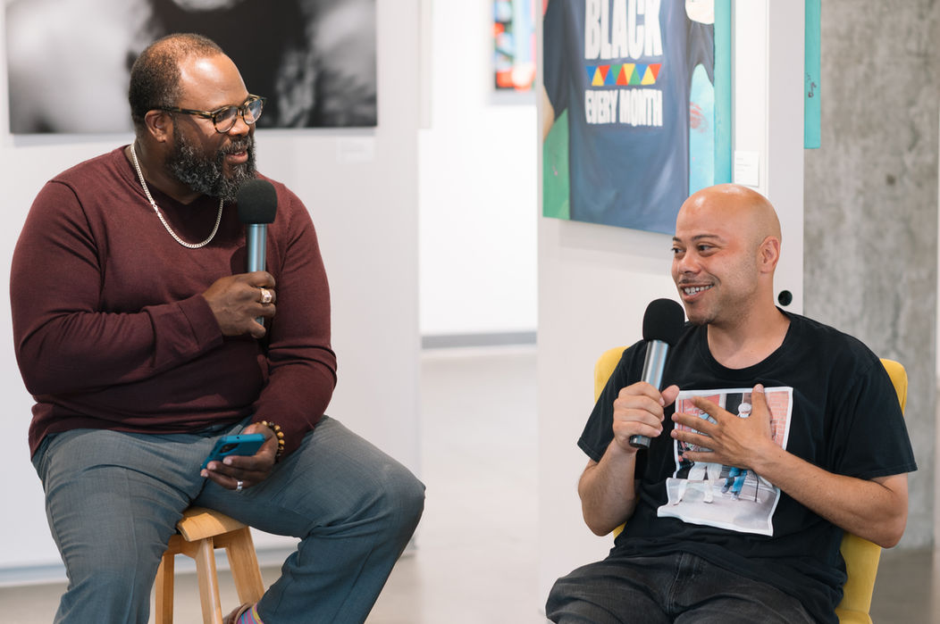 Two men in conversation at an art gallery