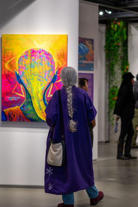 Woman viewing vibrant abstract painting at art gallery