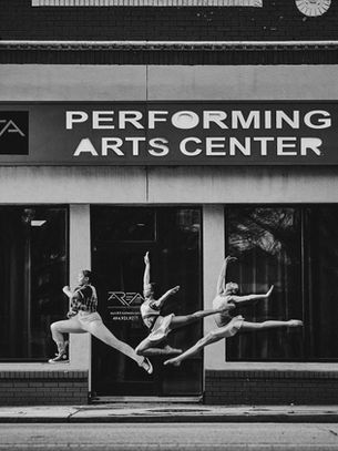 Three dancers in midair outside AREA Performing Arts Center in Atlanta.