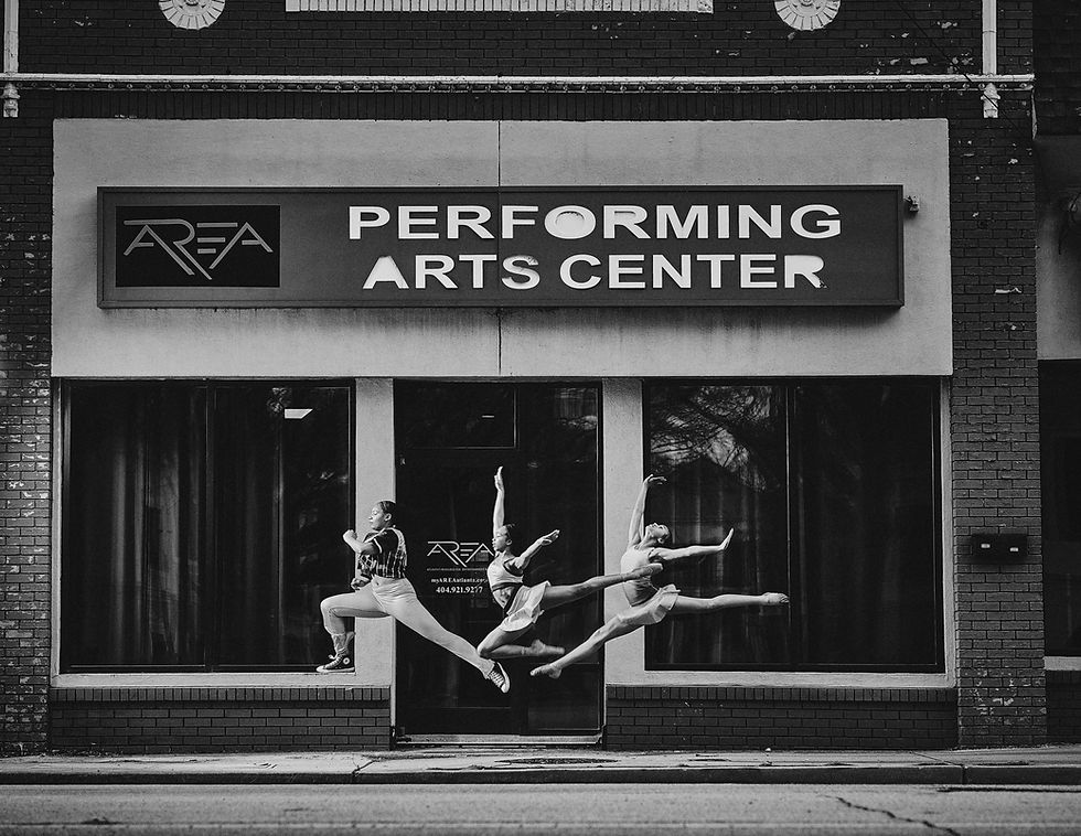 Three dancers in midair outside AREA Performing Arts Center in Atlanta.