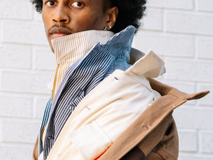 Black man with afro modeling fall fashion workwear by brand Mannish