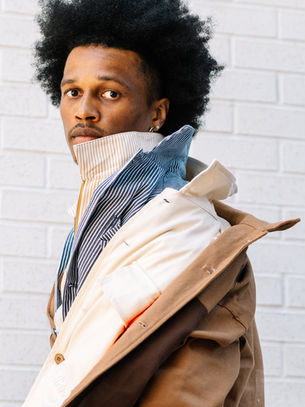 Black man with afro modeling fall fashion workwear by brand Mannish