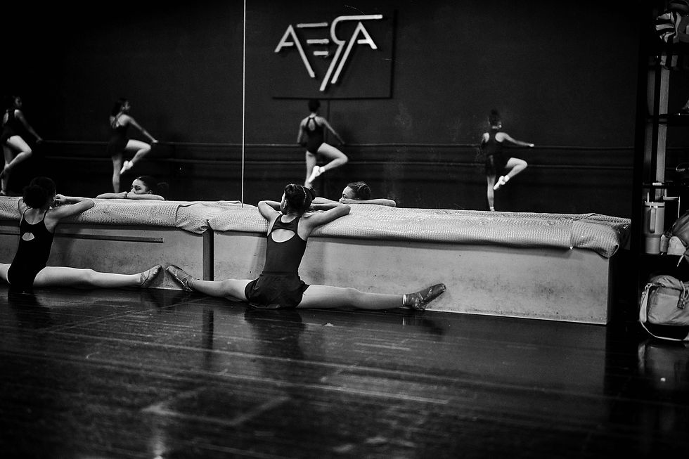 Students practice floor stretches in the mirrored studio at AREA Atlanta.