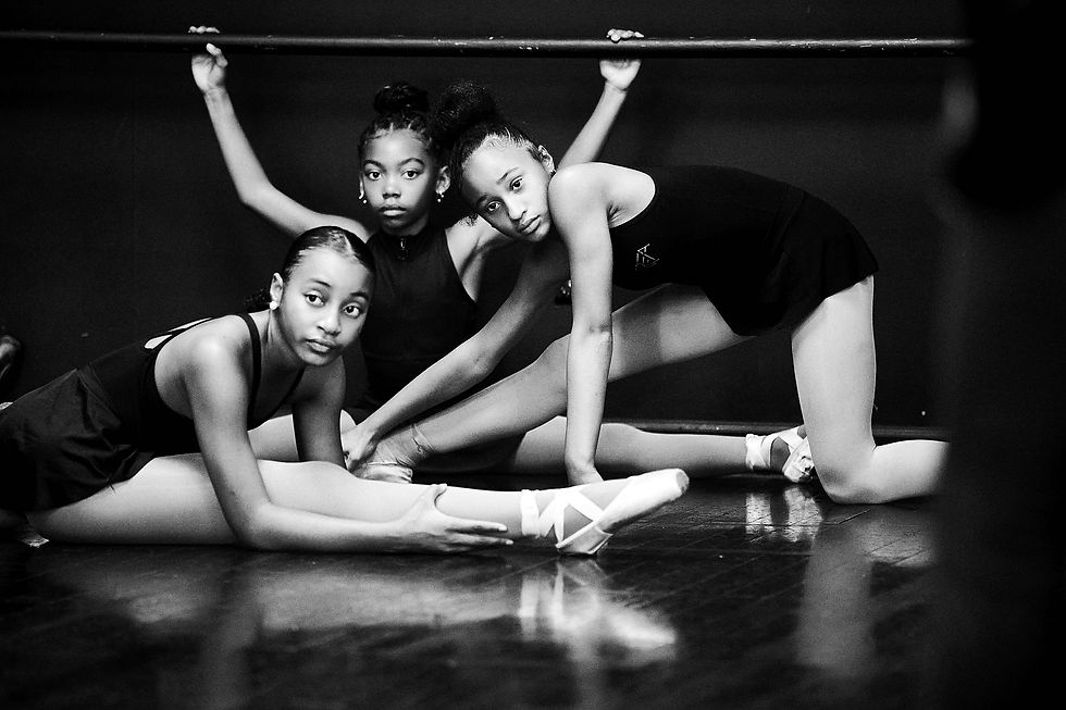 Three dancers look toward the camera during a floor exercise.