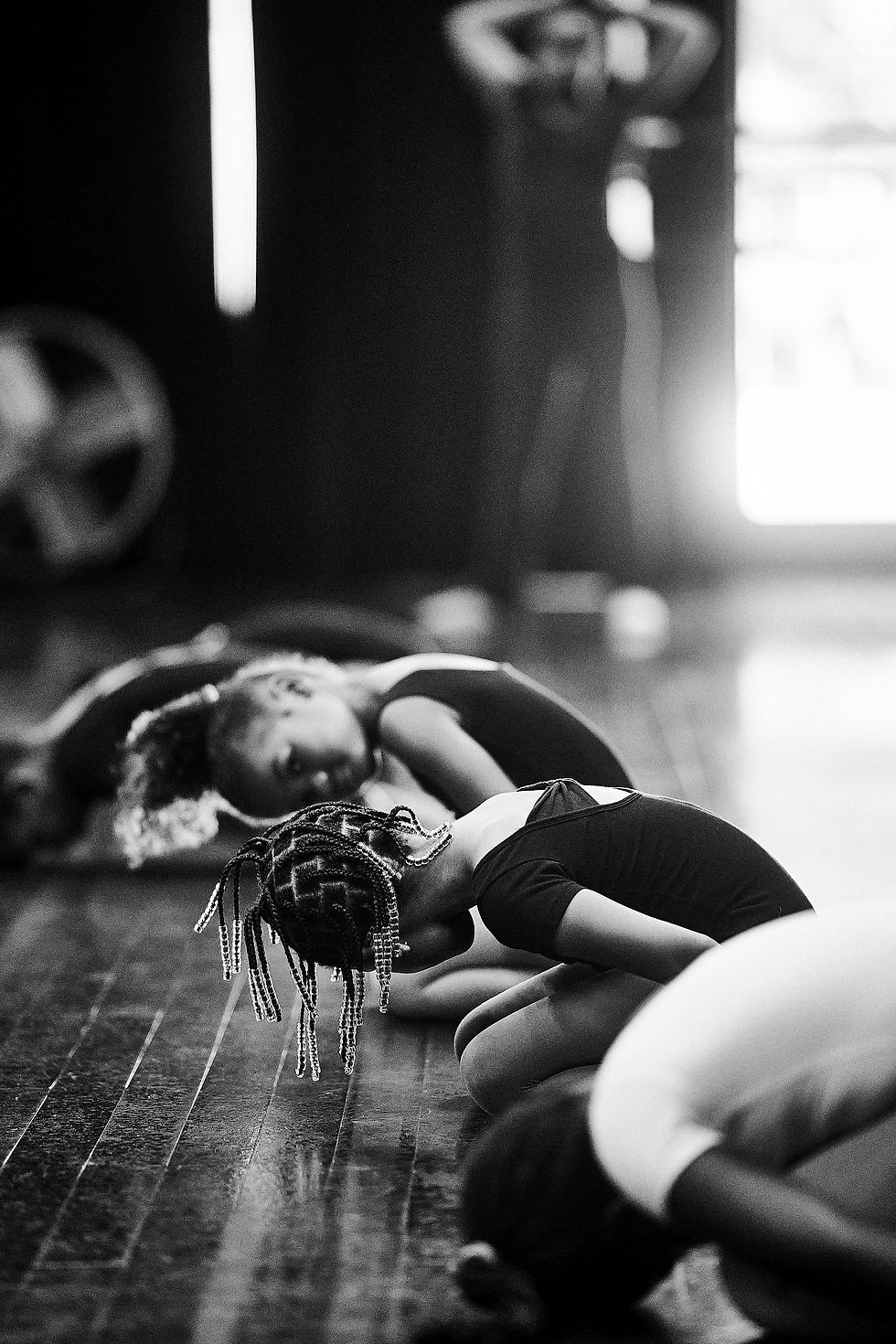 Dancers stretch together during a training session at AREA Atlanta.